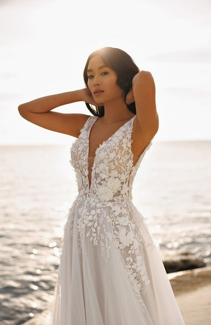 Model wearing a gown and posing near the ocean